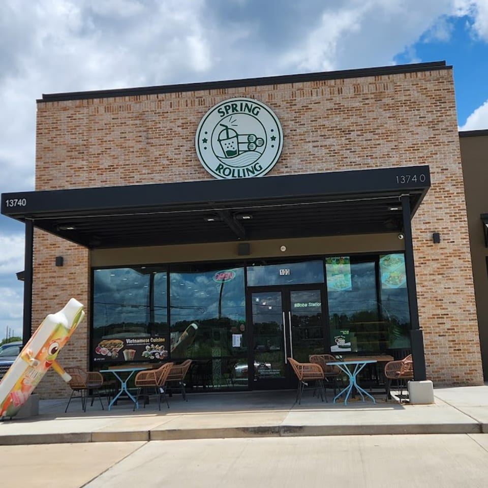 Spring Rolling Vietnamese restaurant exterior with a large logo, outdoor seating, and a giant spring roll mascot.