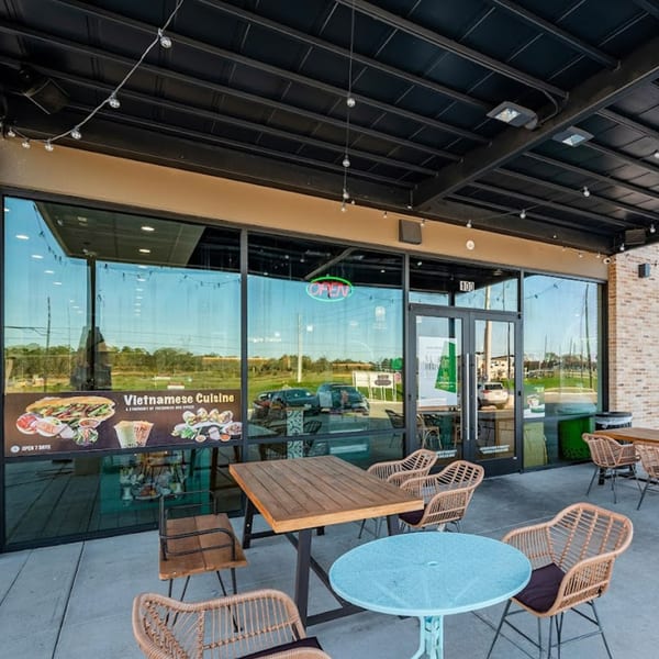 Spring Rolling Vietnamese restaurant exterior with outdoor seating, large windows, and a menu display.