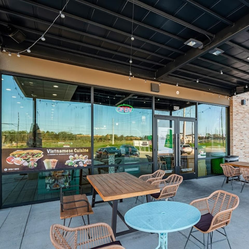 Spring Rolling Vietnamese restaurant exterior with outdoor seating, large windows, and a menu display.